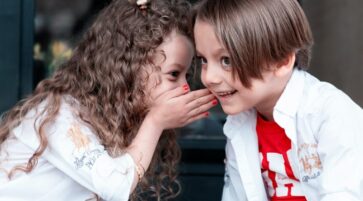 woman in white long sleeve shirt kissing girl in white long sleeve shirt