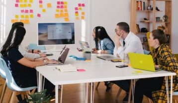 five person by table watching turned on white iMac