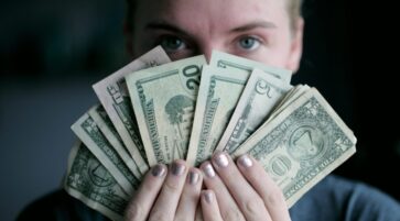 Young woman holding money.